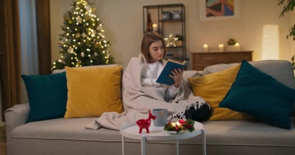 Junges Mädchen Sitzt Auf Sofa Wohnzimmer Und Liest Buch Sie — Stockvideo
