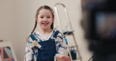 Odanın ortasında, gri gözlü, kahverengi saçlı, iki örgülü 8 yaşında bir kız duruyordu. Çocuk anne ve babasının kamerasında onarım izlenimlerini kaydediyor. Ünlü bir blogcu olmayı hayal ediyor.