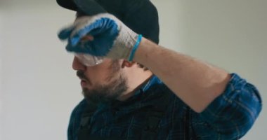 Yıllarca inşaat sahalarında çalışan deneyimli bir işçinin bir daireyi yenilemesi, bir evi bitirmesi, fayansları çekiçlemesi ve güvenlik gözlükleri vardır..