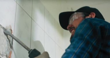 Bir inşaat işçisi tarafından çekiçle aşındırılmış fayanslar..