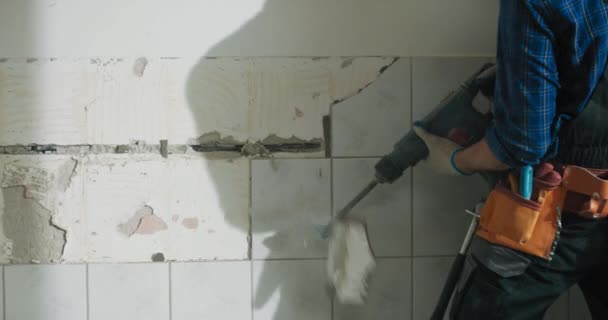 집중력있는 화장실에서 타일을 망치는 개조하는 현장에서 일하는 남자가 보호용 장갑으로 — 비디오
