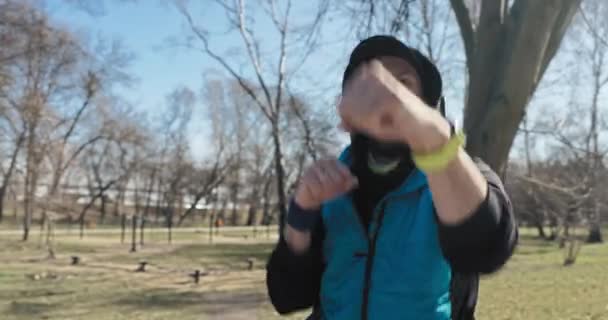 Sportler Bei Übungen Boxt Mann Sportkleidung Mit Kapuze Und Kopfhörer — Stockvideo