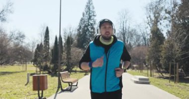 Sakallı adam sabah koşusuna çıktı. Parkta koşar, etrafa bakar ve derin derin nefes alır. Adamın elinde mavi kolsuz, siyah şapkalı bir saat var. Müzik kulaklıkla çalıyor..