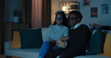 Afrikalı görünümlü bir adam randevuya kız davet etti. Kanepede oturuyorlar, 3D gözlük takıyorlar ve film izliyorlar. Genç adam kız gözlüklerini dikkatlice ayarladı. Patlamış mısır yiyip gülüyorlar..