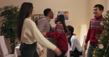 Karı koca Noel 'i kutlamaya gelen konukları selamlıyor. Onlar birbirini selamladı ve kucakladı. Süveter giyen esmer kadın güzel dekore edilmiş Noel ağacını ve davetlileri masaya davet etti..