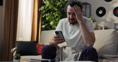 Her zaman görüşüyoruz. Evdeki kanepede otururken akıllı telefonunu kullanan neşeli, yakışıklı bir genç adam. Adam mesajlara cevap yazıyor, gülümseyerek kameraya bakıyor..