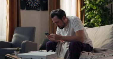 Uyandıktan sonra telefondaki mesajları kontrol eden, ödenmemiş kredi taksitleri, yüksek elektrik ve gaz faturaları hakkında bir e-posta atan bir adam....