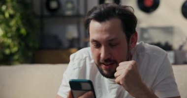 Adamın biri oturma odasındaki langırt maçını izliyor. Az önce gol atan takım için tezahürat yapıyor. Adam telefona bağırıyor..