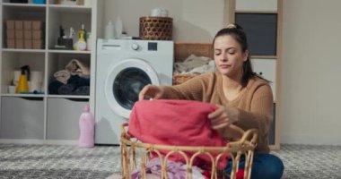 Annem banyoda oturmuş kıyafetleri düzenliyor diye endişeleniyor. Elbiseleri sepetten çıkarıp yere koyuyor. Gülümseyen kızı odaya girer, annesinin kucağına oturur ve kıyafetleri sıralamaya yardım eder.