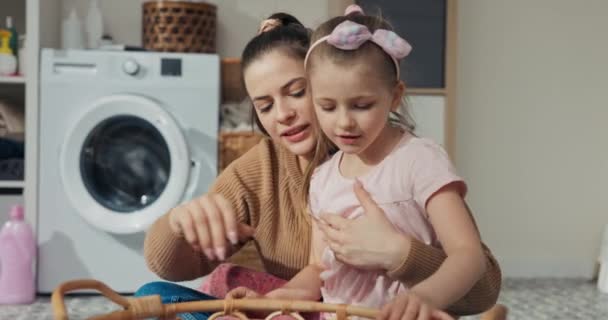 Młoda Matka Siedmioletnia Córka Sortują Ubrania Prania Wyciągają Skarpetki Różową — Wideo stockowe