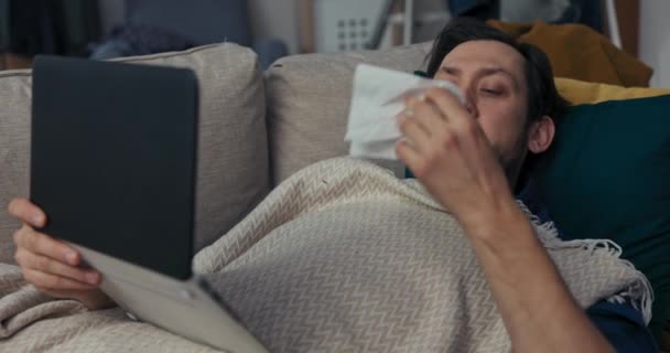 Одинокий Человек Бородой Черными Волосами Лежит Диване Покрыт Одеялом Человек — стоковое видео