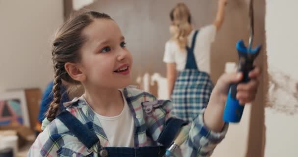 Schöne Siebenjährige Mädchen Mit Zöpfen Bemalt Wand Mit Walze Und — Stockvideo