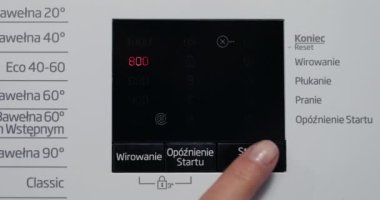 Son teknoloji dijital ekranda el yapımı çamaşır seti seçmeye odaklan. Kontrol panelinde dokunmatik ekranı olan otomatik çamaşır makinesinin yakın görüntüsü. Kız tuşları başlat ya da durdur.