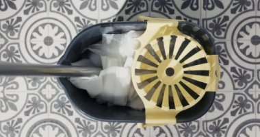 Kova içinde yerleri paspasladıktan sonra paspas sıkarak. Üst görünüm yakın plan.