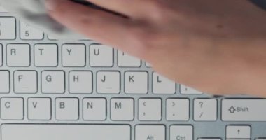 Hijyen ve dezenfeksiyon kavramı - bilgisayar klavyesini kağıt mendille temizleyen kadına yakın çekim.