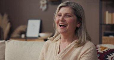 Yaşlı bir kadın kanepeye oturur ve çocuklar geldiğinde şaşkınlıkla gülerek ağzını açar. Kızının mutluluğu yüzünü duygularla kaplıyor..