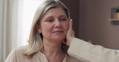 Kız sevgiyle annesinin yanağını okşuyor, destek, sevgi ve şefkat gösteriyor. Aile yakınlığı.