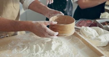 Pişirme, ev yapımı pizza hazırlama. Seçici odak, sevimli, meraklı bir anaokulu kızı olan genç babayı memnun etti. Keyfi yerindeydi. Tahta tahtada un süzüyor, ev yapımı hamur hazırlıyordu..