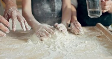 Seçici odak aile elleri hamur yoğurur ahşap yüzey üzerine su dökerek ev yapımı lezzetli pizza makarnası için hamur hazırlar. Mutlu aile kavramı. Çocuklu ebeveynler zaman geçirir.