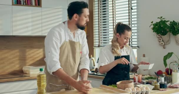 Młoda Urocza Żona Pomaga Przystojnemu Mężowi Gotować Nowoczesnej Kuchni Kobieta — Wideo stockowe