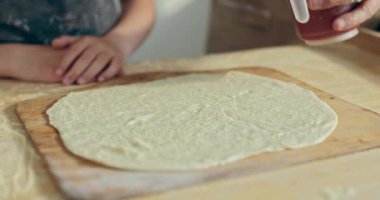 Fatjer ve küçük kızı hafif mutfakta pizza hazırlıyorlar. Domates sosuna odaklanıp ev yapımı pizza hamuruna odaklan. Pizza pişiriyorum. Annem için yemek hazırlıyorum..