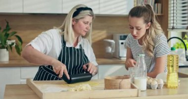 Anne ve kızı evdeki modern mutfakta. Mutlu yaşlı anne, ev yapımı hamur işlerini kızına öğreterek ev yapımı makarna gnocchi yapmayı öğretiyor. Genç meraklı kız izliyor...