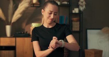 Kapalı alanda egzersiz. Bayan sporcu aktivitelerini izlemek için spor bandını kullanıyor..