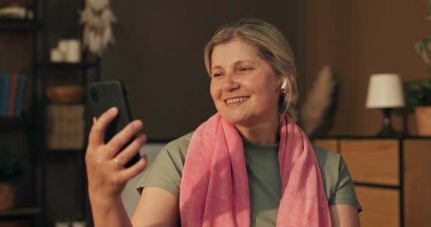 Rentnerin Sitzt Auf Gymnastikball Wohnzimmer Und Telefoniert Vor Laufender Kamera — Stockvideo