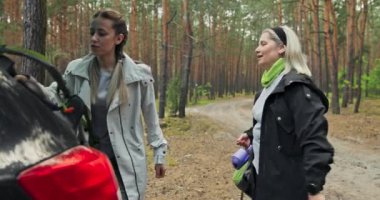 Saçları örgülü, orta yaşlı bir annesi olan mutlu bir genç kız. Sırt çantalarını minderlerle birlikte çıkarıyor ve onları bir arabanın bagajına koyuyor. Yürüyüş yaptıktan sonra yorulan kadınlar eve dönerken ormanda egzersiz yapıyorlar..