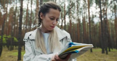 Sarışın, saç örgülü, spor giysili güzel bir kadın elinde haritayla ormanın ortasında eve dönüş yolunu arıyor. Aile, ormanda yürüyüş yaparken spor yaparken kaybolmuş..