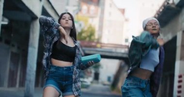 Rahat kıyafetler giymiş iki genç kız tarafından yapılan hip-hop sokak dansı. Kızlar ellerinde bir hoparlör tutuyorlar ve koreografilerine müzik giriyor..