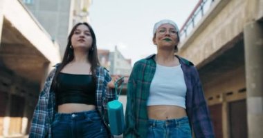 İki genç cadde boyunca bol giysiler içinde yürür ve kızların atletik karınlarını ortaya çıkarır. Elimizde, bir uygulama sayesinde kablosuz olarak müziği açan bir telefona bağlı taşınabilir bir hoparlör var..