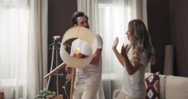 Mutlu, mutlu, genç bir kadın ve yakışıklı bir kocası var. Yeni modern dairelerde dans ediyorlar. Lambalarla dans ediyorlar..