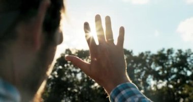 Yaşlı yakışıklı adam, iyi havada gün batımına karşı el ele tutuşup ormanda durup dinlenme konseptine bakıyor. .