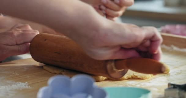 女人的手在木制表面滚着自家做的面团 用滚动式别针教幼稚园可爱的小女儿在桌上端着自家做的饼干饼干切碎 — 图库视频影像