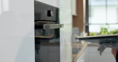 Yeni modern endüstriyel fırının seçici odak noktasını yakından çek. Kadın eli pişirme tepsisi ile ev yapımı ev yapımı bisküvileri pişirmek için farklı şekillerde koyar. Akşam yemeğini hazırlıyorum..