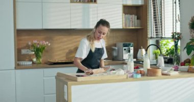 Modern kulaklıklarda oldukça sevimli genç bir kadın... müzik dinlerken... yuvarlanan ev yapımı hamuru rulo halinde... raptiye ile şarkı söylerken... çırpıcı çırpıcı mikrofon tutuyor..