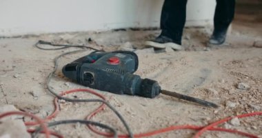 Dairenin tadilatı sırasında eski katın kaldırılması. Elle çalışma fikri. Yıkım çekiçinden keski, seramik seramik seramik parçalar, toz. Erkek işçi tüm gücünü işe verir..