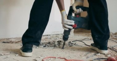 Kaya matkabını tuttuğu bir adamın bacakları zemini kazıyarak eski kiremitleri onarıyor..