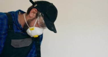 Dairenin tadilatı sırasında eski katın kaldırılması. Elle çalışma fikri. Yıkım çekiçinden keski, seramik seramik seramik parçalar, toz. Erkek işçi tüm gücünü işe verir..