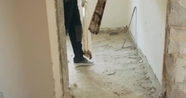 Tadilat sırasında bir evin yıkılması. Bir adam kapı çerçevesini çıkarır ve yere atar..