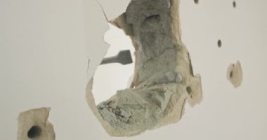 Duvardaki deliğe yakın plan, bir kaya matkabıyla yıkılmış..