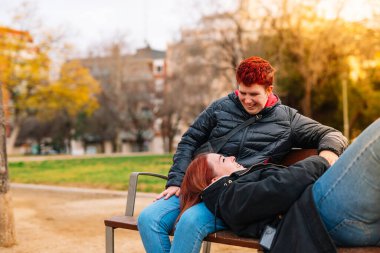 Lezbiyen bir çift birbirlerinin kucağına, halka açık bir parkta bankta yatıyor. Kadınlar birbirini seviyor..