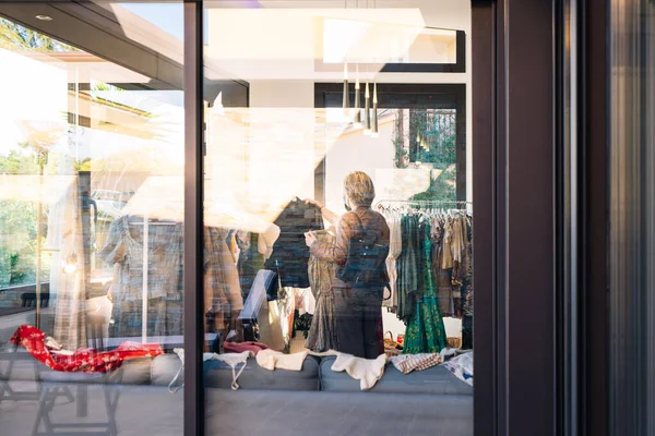 Utsikt från utsidan av två kvinnor inne i en klädaffär. skyltfönster, shoppingkoncept. — Stockfoto