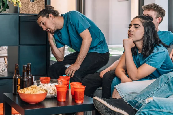 Football fans saddened by their teams defeat. Close-up of a table full of drinks and snacks for a party — Stock Photo, Image