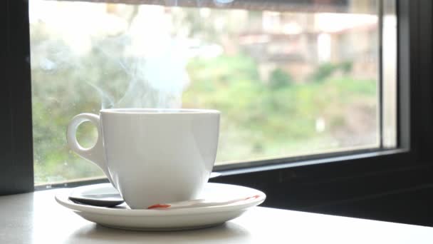 Geschlossene Tasse dampfenden Heißgetränks. Heißgetränk auf dem Tisch in einem Café. Kopierraum. — Stockvideo