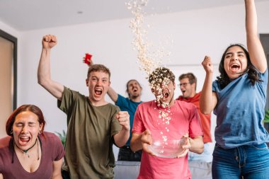 Arkadaşlar sevinçten havalara uçuyor, takımlarının zaferinden sonra havaya patlamış mısır atıyorlar. Bir grup genç evde parti yapıyor..