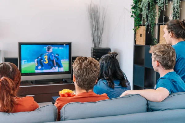 Przyjaciele oglądają mecz piłki nożnej w telewizji w salonie. przestrzeń kopiowania — Zdjęcie stockowe