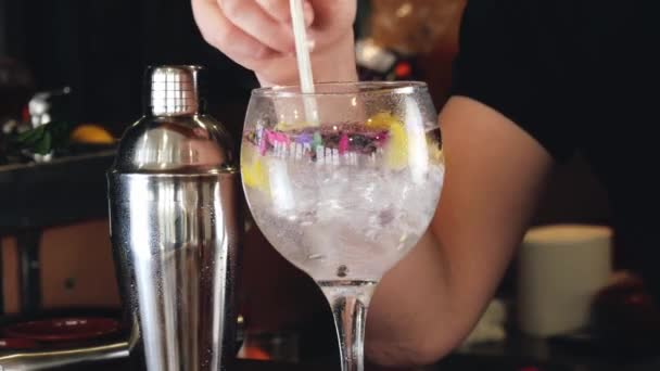 Handen van een ober die een cocktail mengt. roeren van een glas alcoholische dranken. drankjes in een nachtclub. — Stockvideo