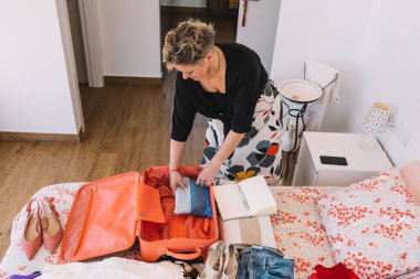 happy mature woman, arranging her luggage, ready to go on a summer trip, weekend. concept leisure and hobby